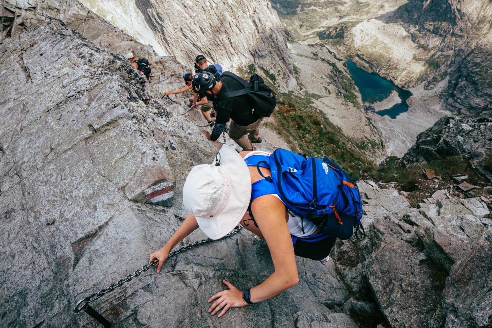 Szlak w Wysokich Tatrach nad alpejskim jeziorem, otoczony skalistymi szczytami