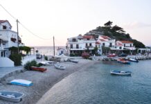 Małe wyspy greckie, które pokochasz bardziej niż Santorini Nadmorska wioska na Samos o zachodzie słońca z łodziami i tawernami